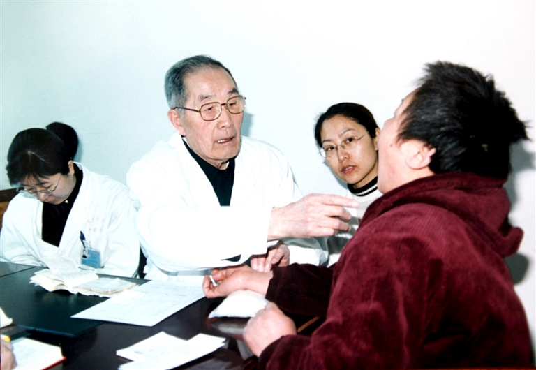 国医大师任继学(左2)为患者诊察。