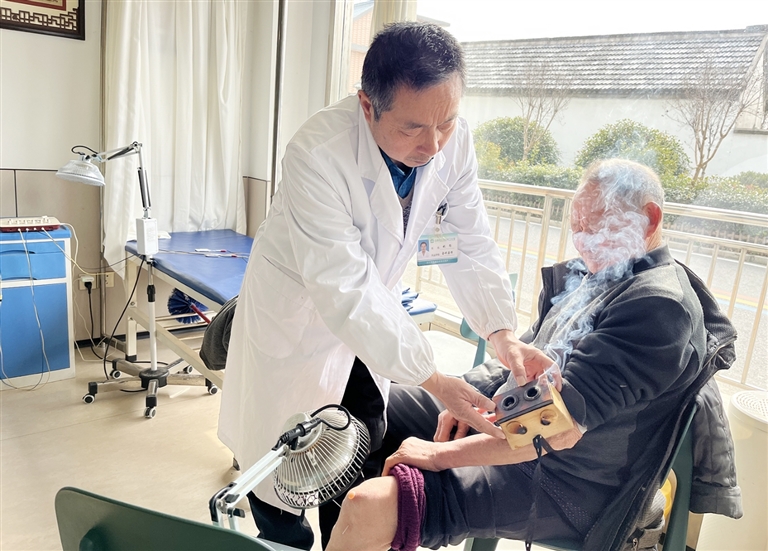 临塔村卫生室村医姚循为村民王登明做艾灸治疗。 龚骏摄