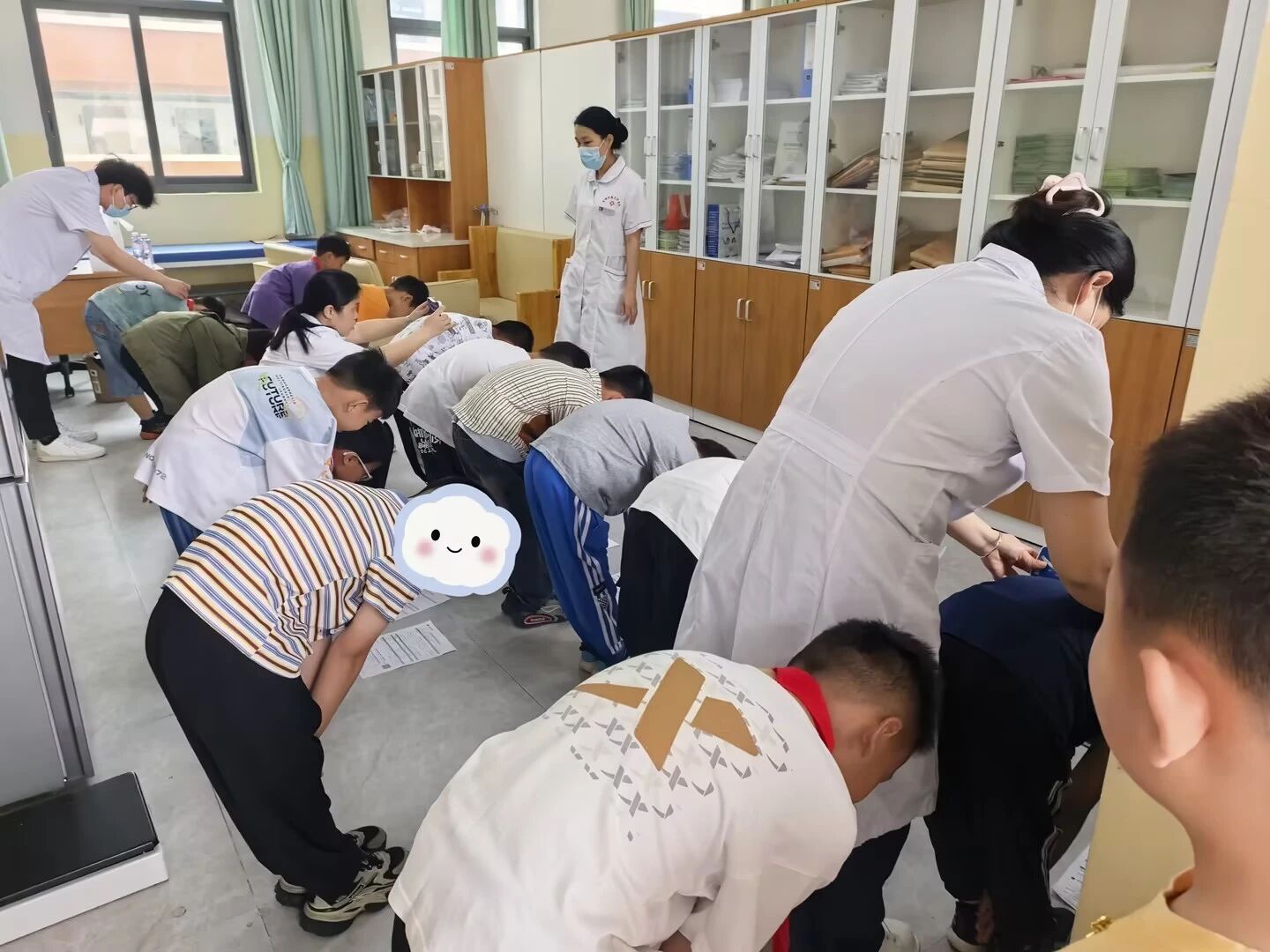 医护人员为孩子们进行脊柱侧弯检查。