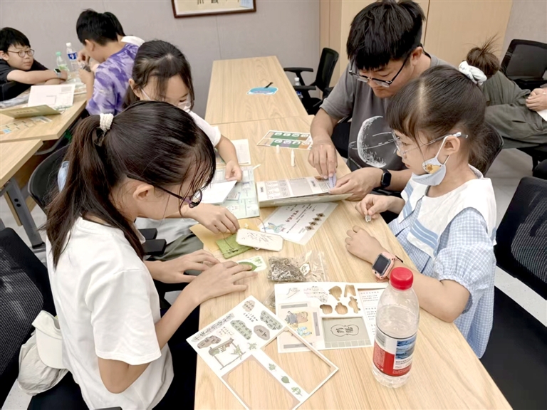 学生们在老师的指导下制作香囊。