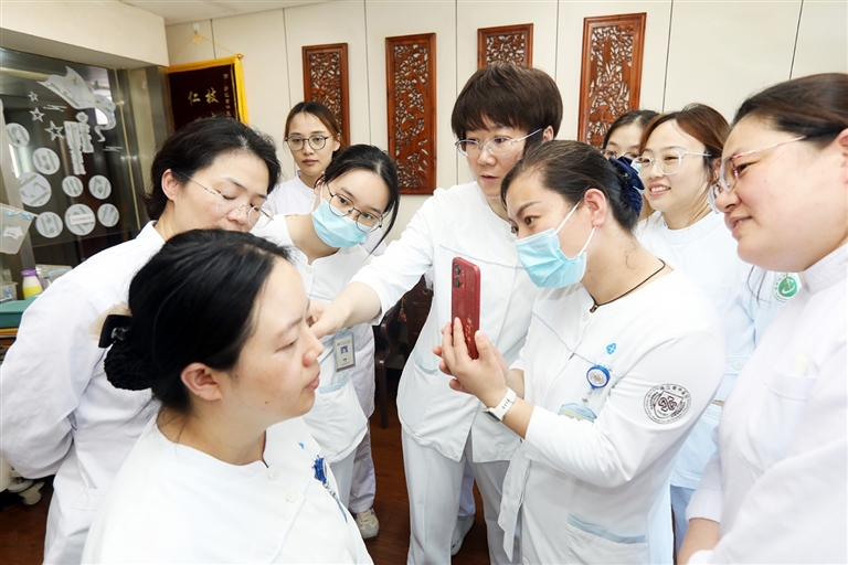 图为该院医务人员为基层中医院护士讲解中医护理适宜技术。 本报记者 于伟摄