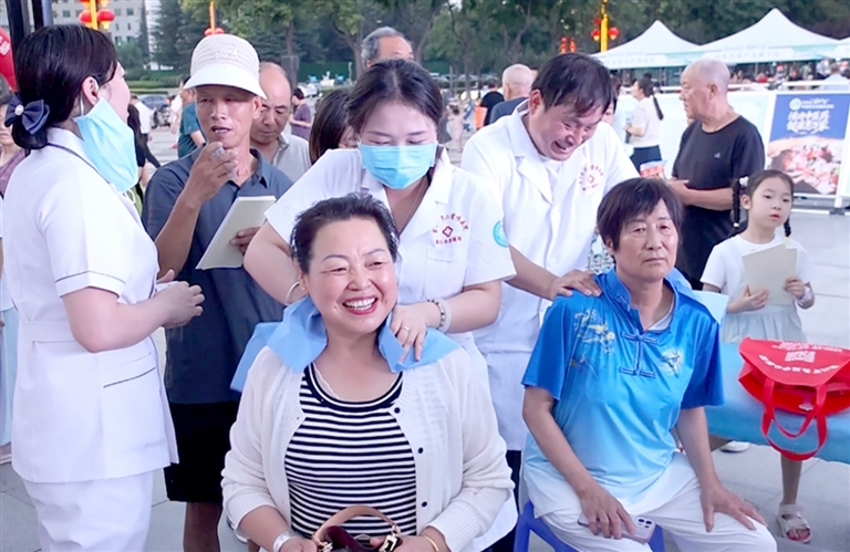 医务人员在为群众进行肩颈推拿按摩。